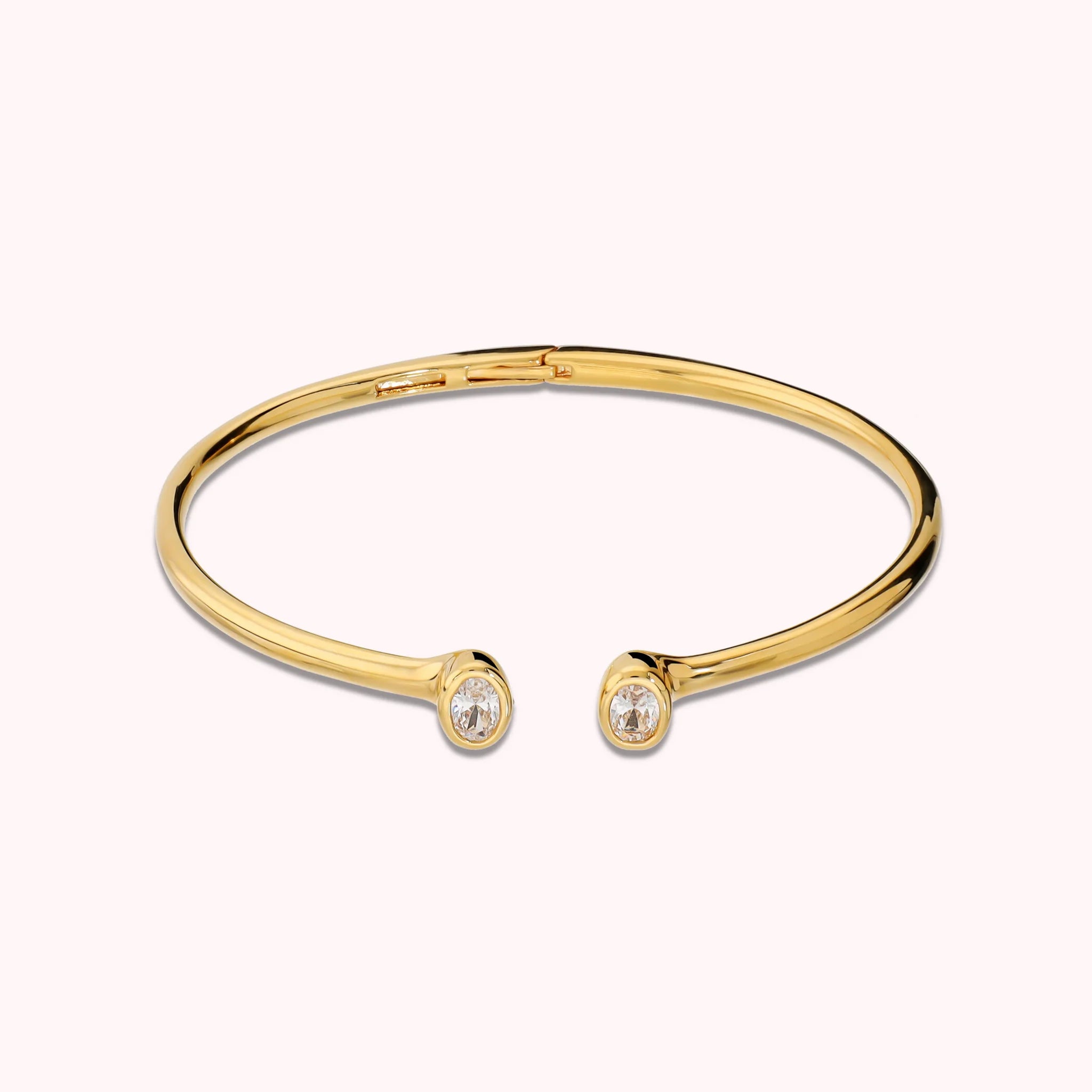 Hinged rigid bangle with double oval cubic zirconia, plated with 18Kt gold